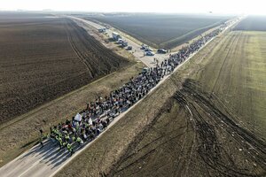 Luftbild einer Menschenmenge, die auf einer einsamen Landstraße wandert