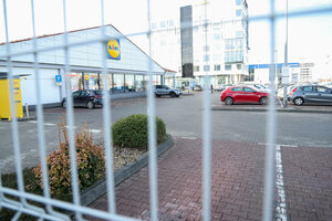 Ein halbvoler Parkplatz vor einem Supermarkt.