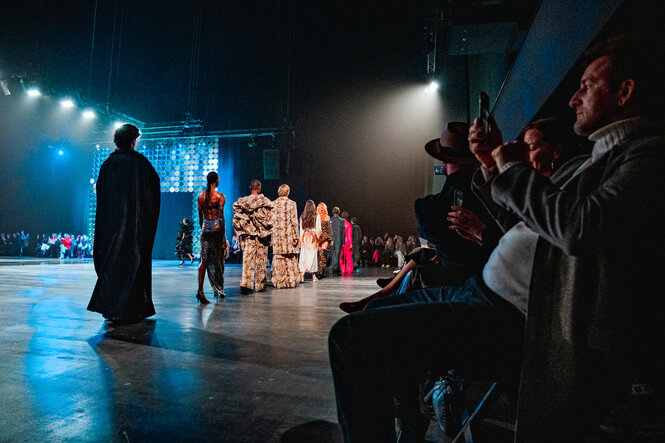 Models und Zuschauer:innen bei einer Modeshow.