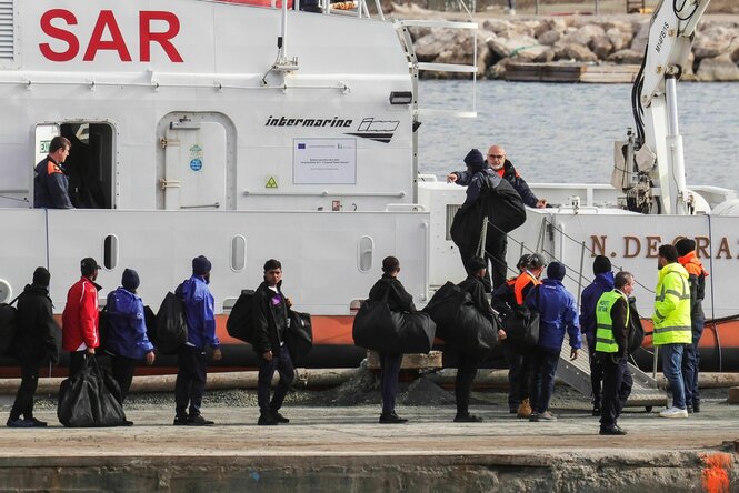 Nach Albanien und zurück: Migrant*innen besteigen im Hafen von Shengjin in Albanien ein Schiff der italienischen Küstenwache.