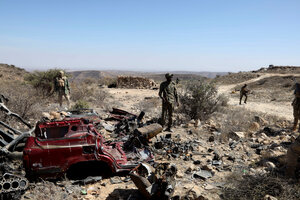 Puntland security forces stand guard near the wreckage of a vehicle after capturing an ISIS base in Cal Miskaad mountain range in Bari, east of the Gulf of Aden in the city of Bosasso, Puntland