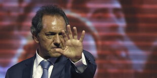 Daniel Scioli hält den ausgestreckten Arm mit offener Hand nach vorne