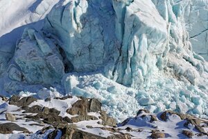 Große Eisfront eines Gletschers mit Spalten und Rissen