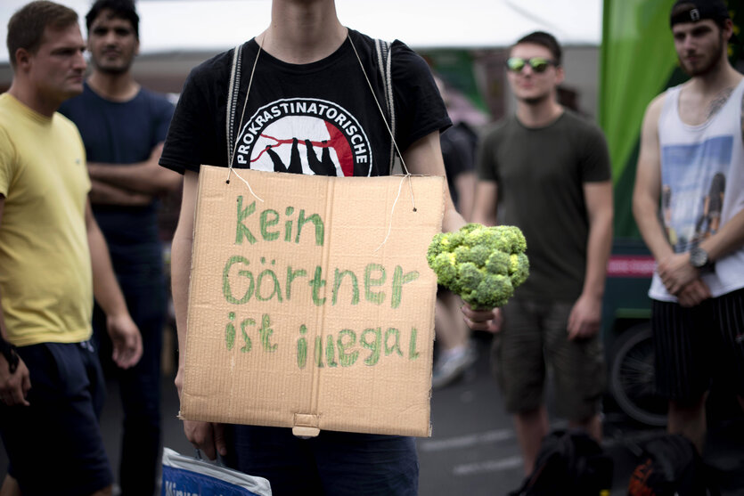 Demonstrant mit Plakat "Kein Gätner ist Illegal" auf der Hanfparade am 13. August 2022