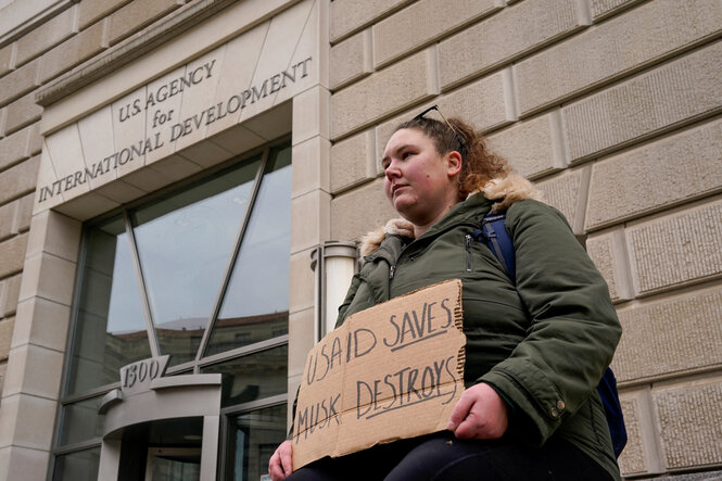 Eine Demonstrantin vor dem USAID-Gebäude in Washington hält ein Schild: USAID rettet, Musk zerstört