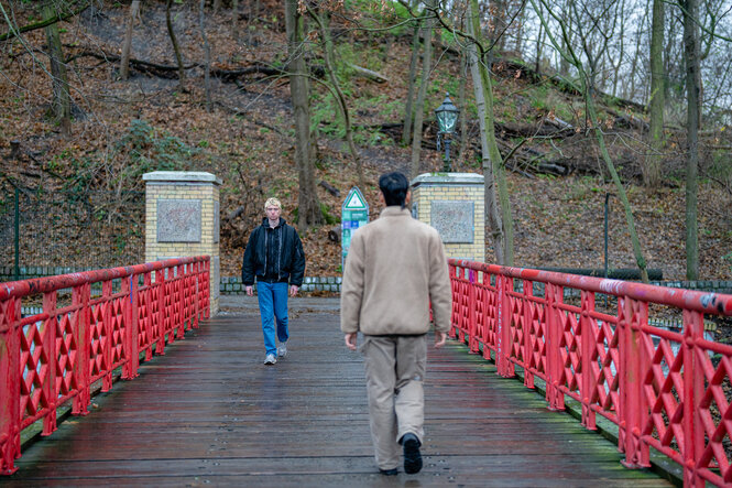 Das Bild zeigt zwei Personen die über eine Brücke laufen.