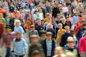 Viele Kinder stehen gedrängt auf einem Schulhof.