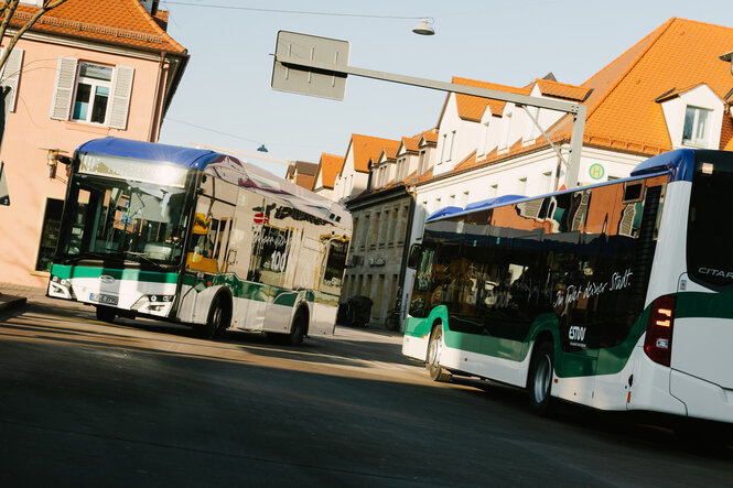 Zwei Busse kreuzen sich in einer Altstadt