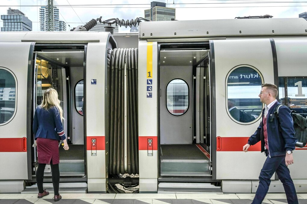 Eine Schaffnerin steht vor einem Zug