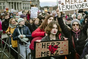 Demonstranten stehen vor dem Reichstag mit Plakaten