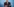 Horst Seehofer steht vor blauem Hintergrund und blickt nach unten