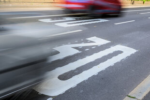 Autos fahren über die Tempo-30-Markierungen auf den Fahrbahnspuren