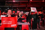 Ines Schwerdtner (l), Bundesvorsitzende der Partei Die Linke, hält während des Bundesparteitags der Linken zur Bundestagswahl 2025 ein Schild hoch, auf dem steht «Alle wollen regieren. Wir wollen verändern».