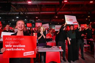 Ines Schwerdtner (l), Bundesvorsitzende der Partei Die Linke, hält während des Bundesparteitags der Linken zur Bundestagswahl 2025 ein Schild hoch, auf dem steht «Alle wollen regieren. Wir wollen verändern».