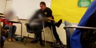 Ein Polizist wirft eine Schülerin durch ein Klassenzimmer.
