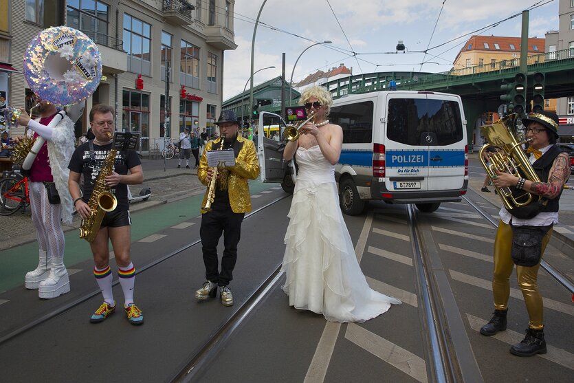 Fünf Tunten stehen auf der Straße und machen Musik und damit Protest gegen Verdrängung: ein Foto Aus der Fotoreportage ?Kampf um das Tuntenhaus? zum Thema der Ausstellung ?Wohnst du noch?"