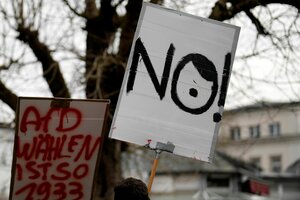 Zu sehen sind zwei Protestschilder. Auf einem steht 