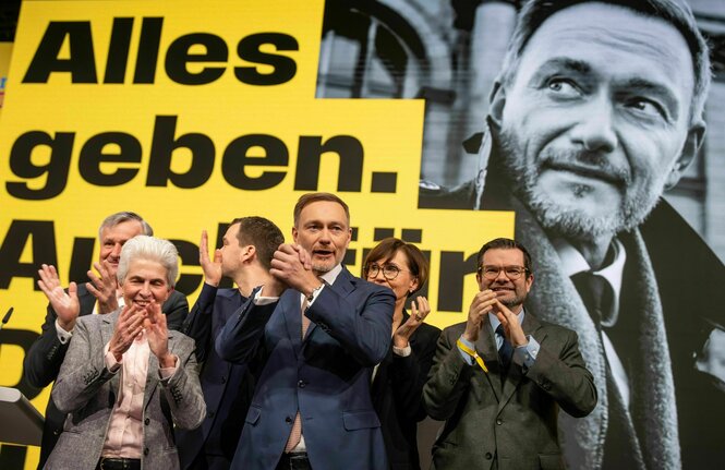 Christian Lindner steht nach beim Bundesparteitag der FDP vor der Bundestagswahl winkend auf der Bühne.