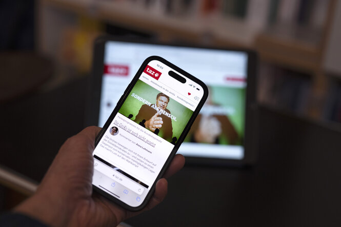 Zu sehen ist ein Smartphone, auf dessen Bildschirm die taz-App geöffnet ist.