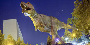 Vor dem Naturmuseum Senckenberg in Frankfurt am Main steht ein lebensgroß nachgebildeter Dinosaurier.