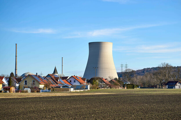 Blick auf den Kühlturm des Kernkraftwerks Isar II mit Wohnhäusern des Dorfs Essenbach im Vordergrund