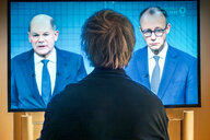 Ein Zuschauer verfolgt das TV-Duell zwischen den Kanzlerkandidaten Scholz und Merz live in der ARD