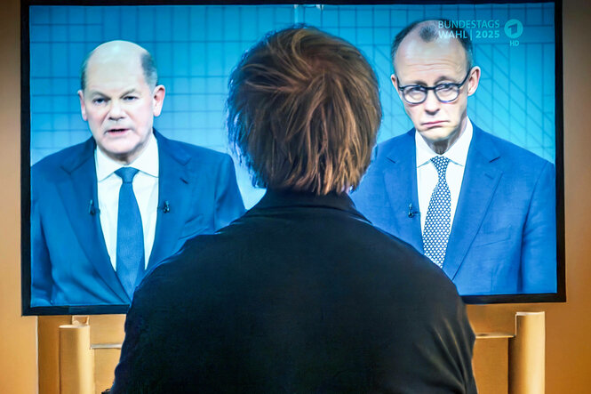 Ein Zuschauer verfolgt das TV-Duell zwischen den Kanzlerkandidaten Scholz und Merz live in der ARD