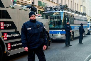 Polizisten stehen vor dem beschlagnahmten Bus