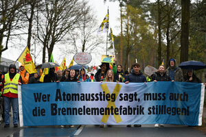 Protestierende hinter einem Banner mit der mit der Aufschrift 