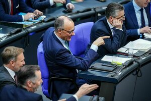 Friedrich Merz sitzt auf seinem Sitz im Plenarsaal des Deutschen Bundestages und gestikuliert