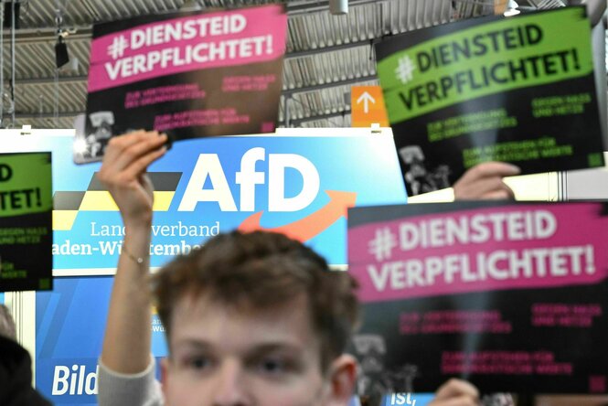 Menschen halten Schilder mit der Aufschrift "Diensteid verpflichtet" in die Höhe