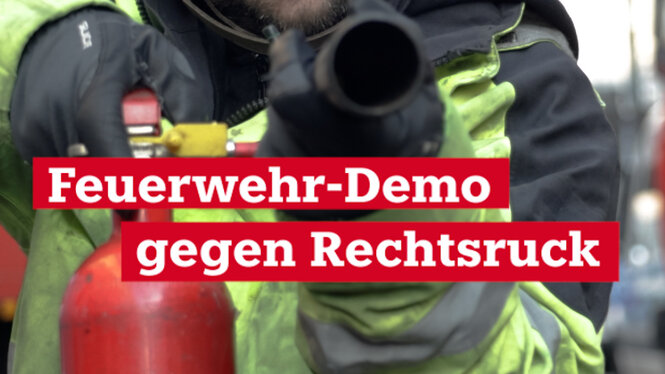 Schriftzug Feuerwehr Demo gegen Rechtsruck dahinter ein Mensch und ein Feuerlöscher