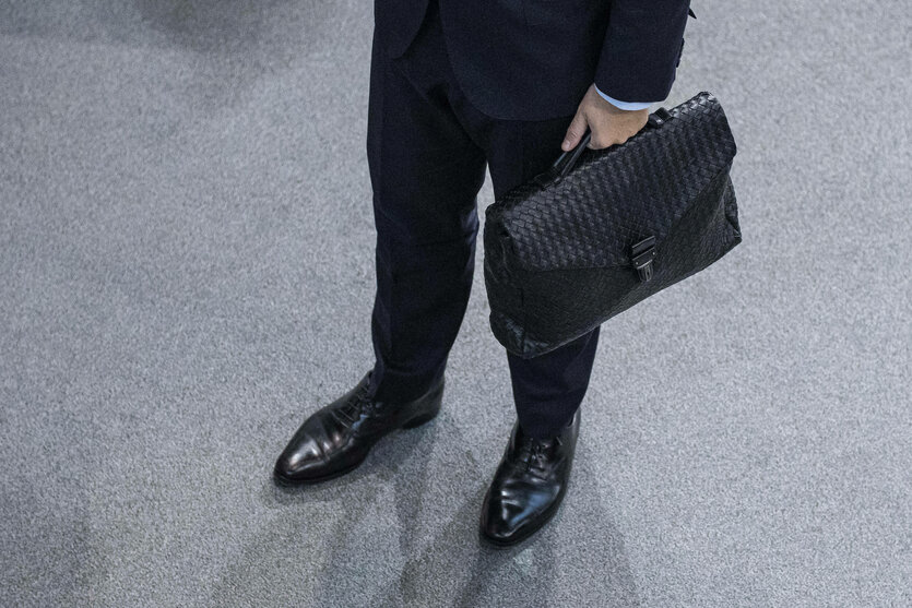 Blick auf die schwarzen Schuhe und die schwarze Handtasche von Christian Lindner