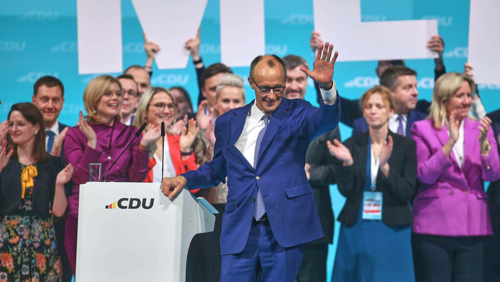 CDU-Parteichef Friedrich Merz wird auf einer Bühne von Frauen und Männern klatschend bejubelt