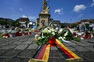 Blumen und Kerzen liegen auf dem Boden eines Marktplatzes