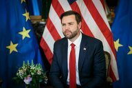 JD Vance vor Fahnen der EU und der USA