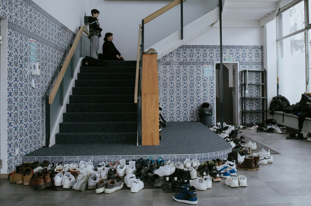 Viele Schuhe in einer Moschee, eine Treppe führt zum Gebetsraum