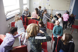 Eine Klassenzimmer mit Kindern die chaotische verteilt sind