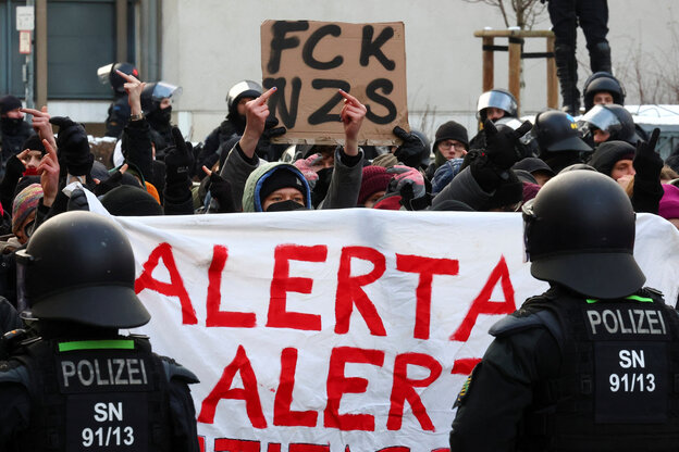 Polizisten stehen vor einem Banner auf dem 