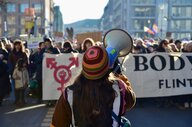 Eine Frau von hinter mit Megafon auf einer Demonstration