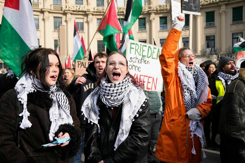 Menschen protestieren mit Palästina-Fahnen und Pali-Tüchern