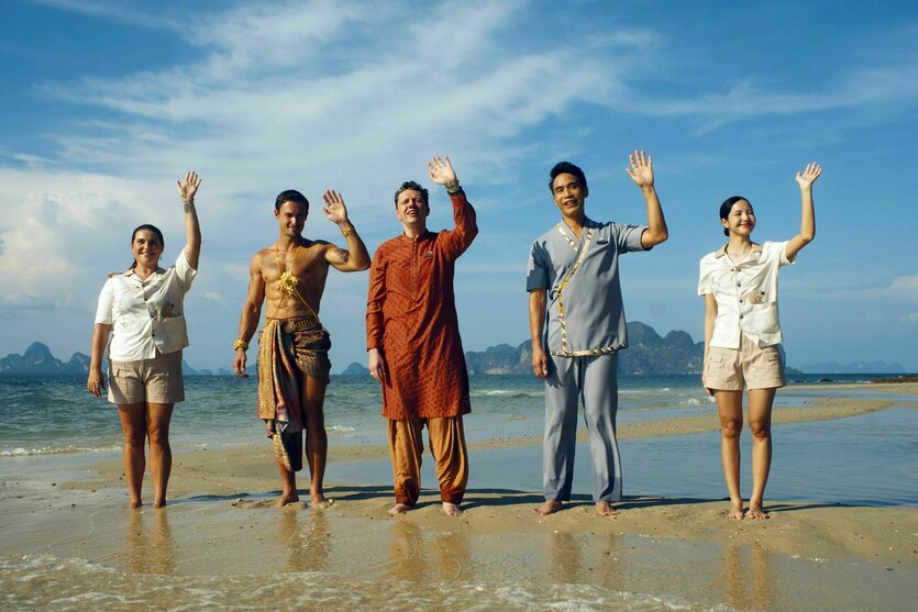 Szene aus einer TV-Serie, Menschen winken an einem Strand