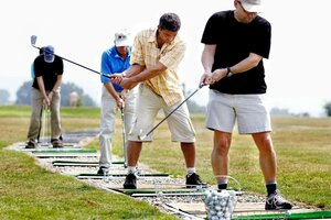 Vier Männer versuchen sich am Golfschlag