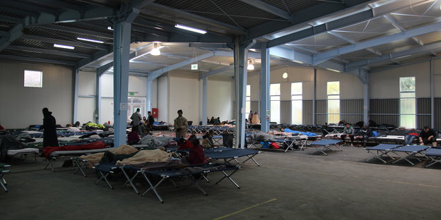 Flüchtlinge in einer Messehalle