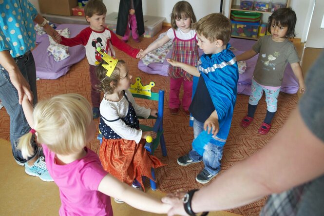 Verkleidete Kinder spielen in einer Kita.