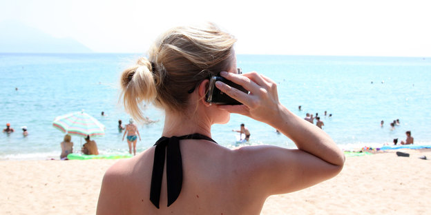 Eine Frau am Strand telefoniert