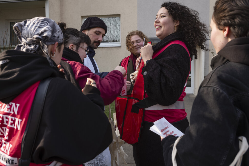 eine Gruppe junger Menschen steht zusammen, zwei Frauen haben lockige Haare