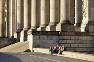 Säulen und Mauern vor dem Eingang des Reichstgasgebäudes in Berlin, auf einer Mauer sitzen junge Frauen