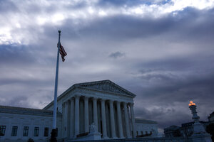 Das Gebäude des Supreme Courts in Washington mit weißen Säulen, düsterem Himmel und einer schlaffen US-Flagge