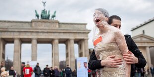 Eine in Klarsichtfolie eingewickelte Frau ist Teil einer Protestaktion von Terre des Femmes